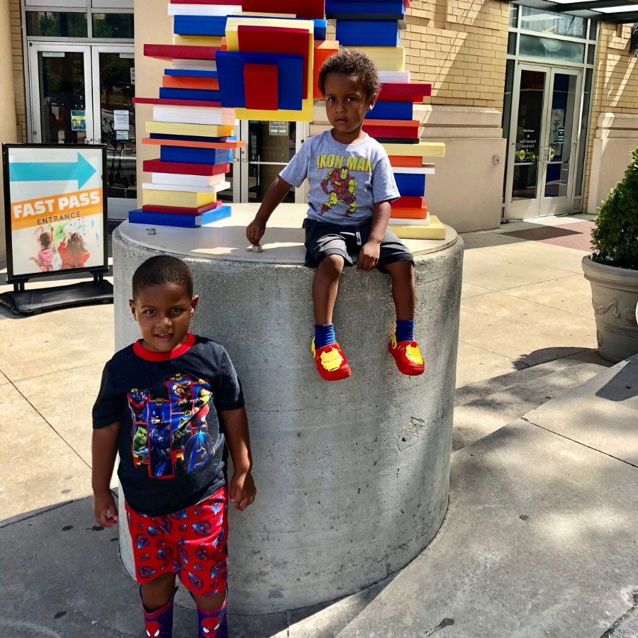 Two young boys with hero outfits pose outside of Children's Museum of Atlanta