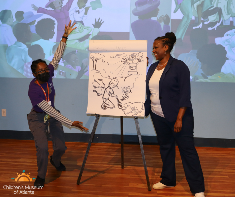 Ms. Grooms and CMA team Member Nashana Pritchett at the CMA Stage with an easel of the drawing they collaborated with the guests.