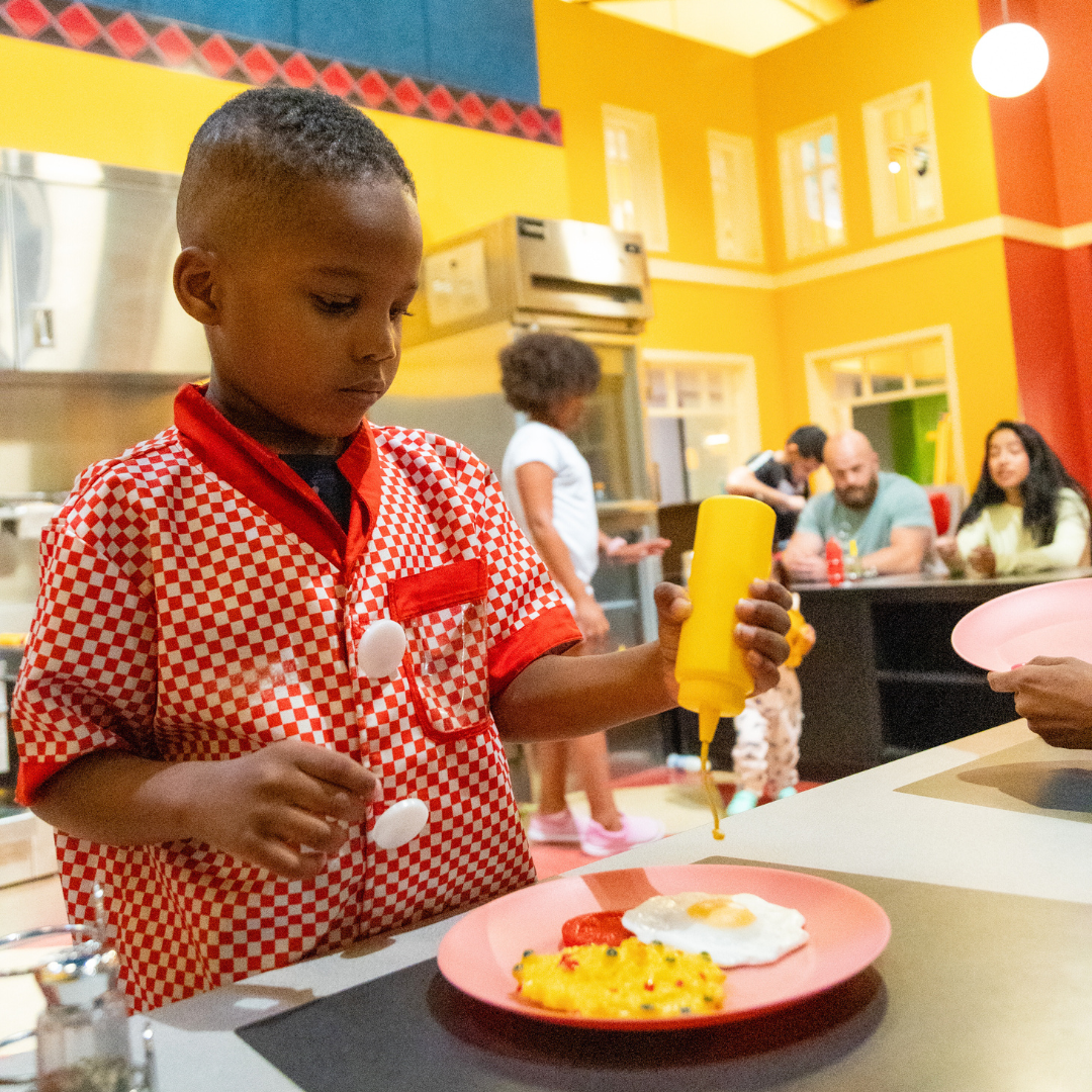 Kid wearing chef apron cooking in diner
