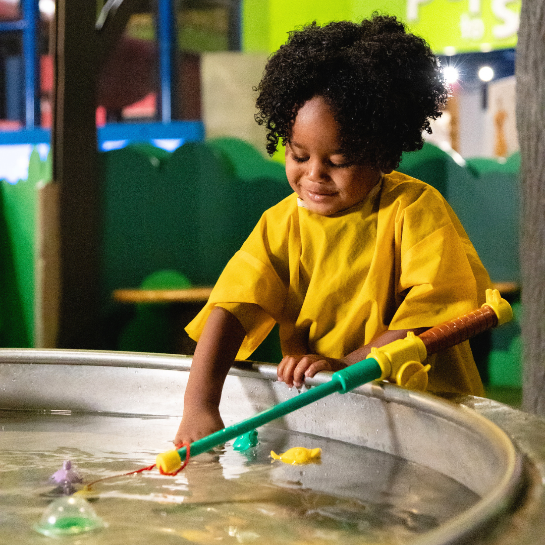 Kid fishing in pond wearing yellow rainvest