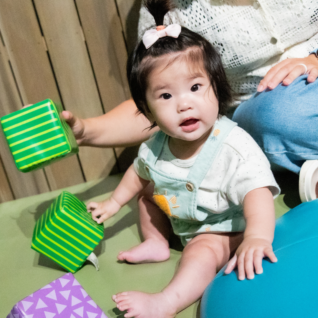 Kid and caregiver playing with blocks in Toddler Zone