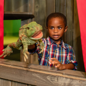 Kid playing with frog puppet
