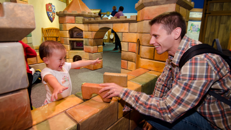 Child and caregiver playing with blocks in the Amazing Castle exhibit